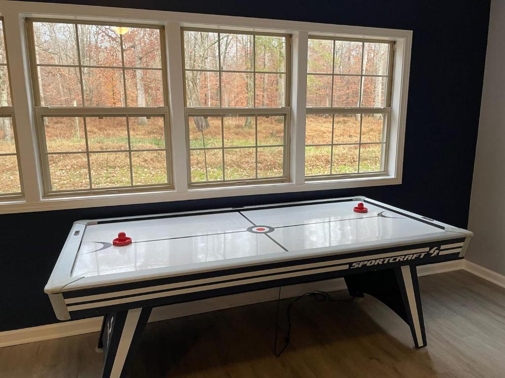 un tavolo da ping pong in una stanza con finestre di Remodeled Cottage With Sunroom a Manchester