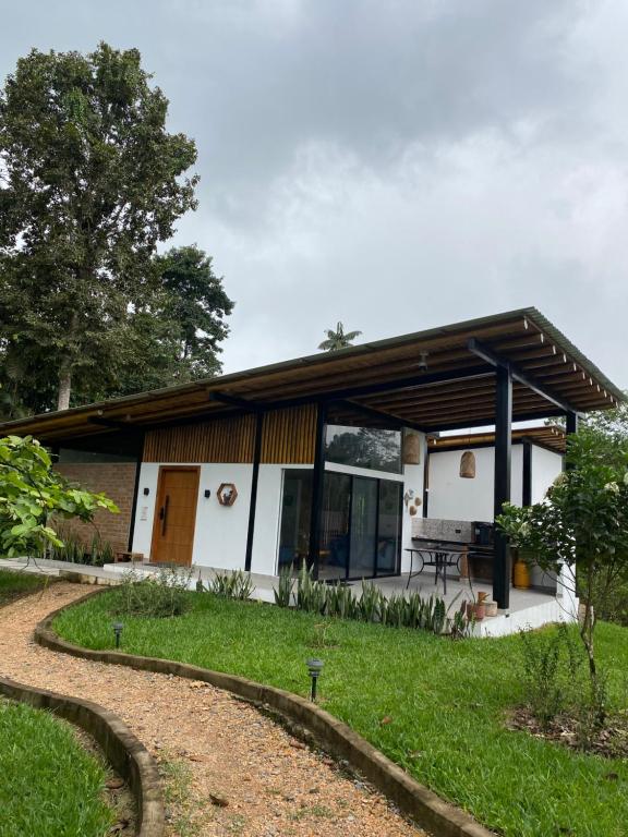 a small white house with a path leading to it at Wasi loma casa campestre in Pedro Vicente Maldonado