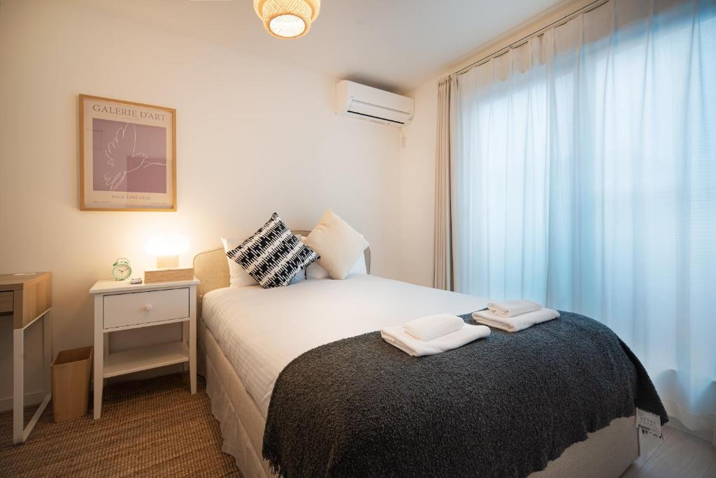 Un dormitorio pequeño con una cama y una ventana. en 静和 旅タイム千本南, en Osaka