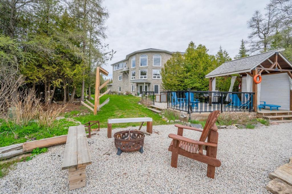 a backyard with benches and a picnic table and a house at Waterfront Sauna Kayaks Sunsets Dog Run in Lion's Head