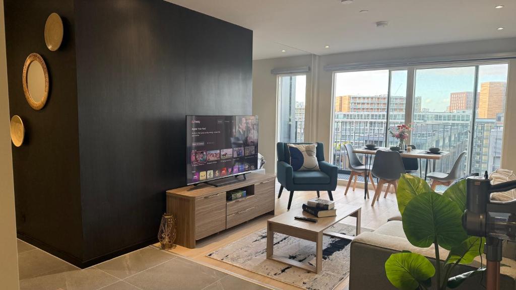 a living room with a television and a table with chairs at Luxury Apartment in City Centre - Free Parking in Manchester
