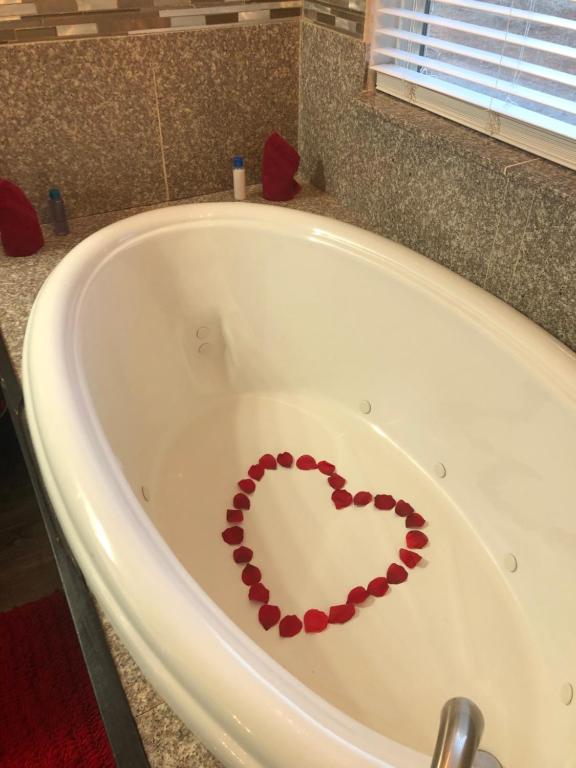 un cuore dipinto sul lato di una vasca da bagno di Cottages At Willow Pond a Guthrie