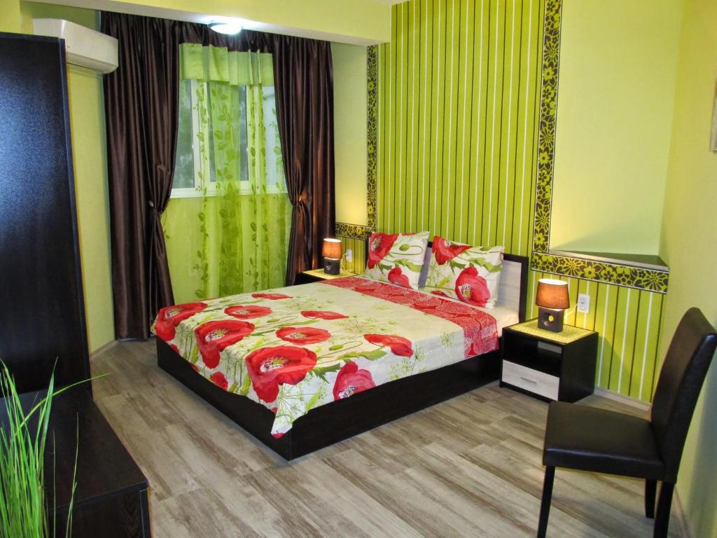 een slaapkamer met een bed en een stoel erin bij Apartments Vasil Levski in Plovdiv