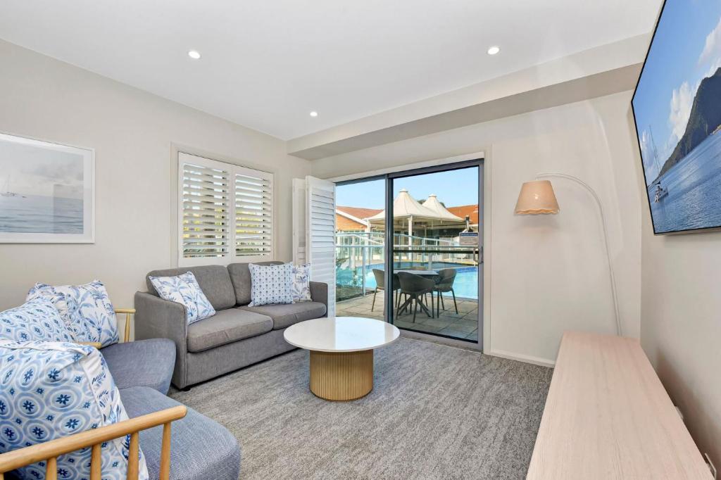 una sala de estar con un sofá y una mesa en Pacific Blue Unit 175 Dual Swim Up, en Salamander Bay