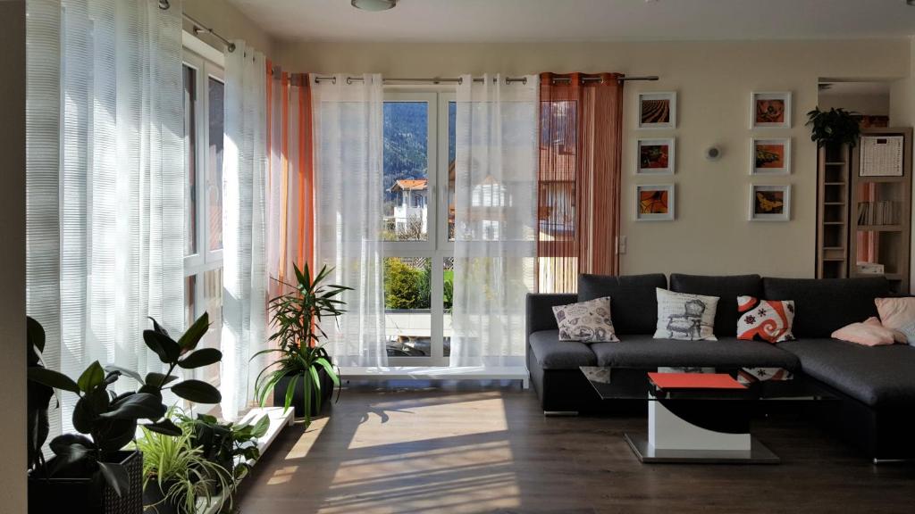 a living room with a couch and a large window at Ferienwohnung Dolomitenpanorama in Oberlienz