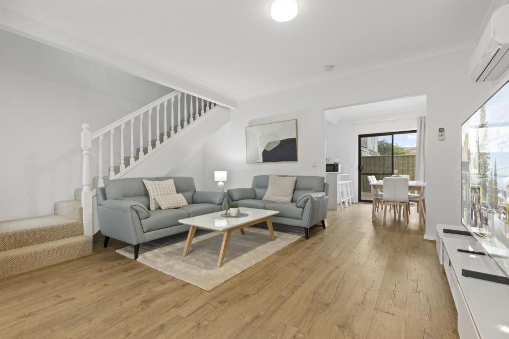 a living room with a couch and a table at Beachside 3-Bed Retreat with BBQ & Garage in Glenelg