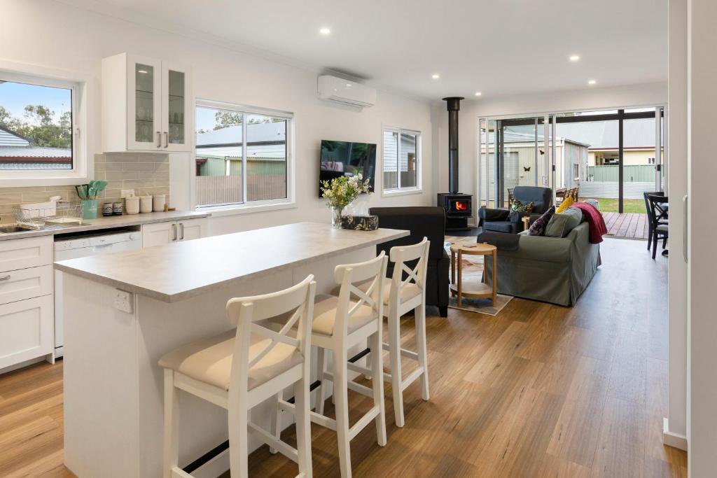 a kitchen and living room with a counter and chairs at Timber Mill Cottage in Mansfield