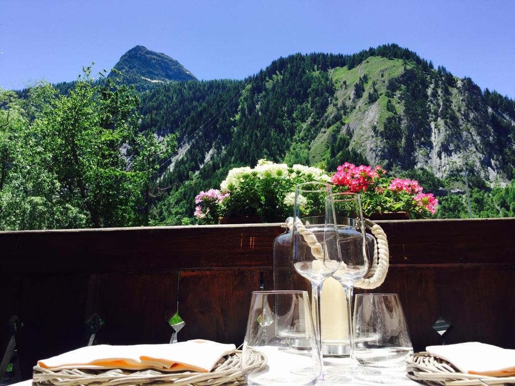 a table with a wine glass on top of a mountain at Shatush Hotel in Courmayeur