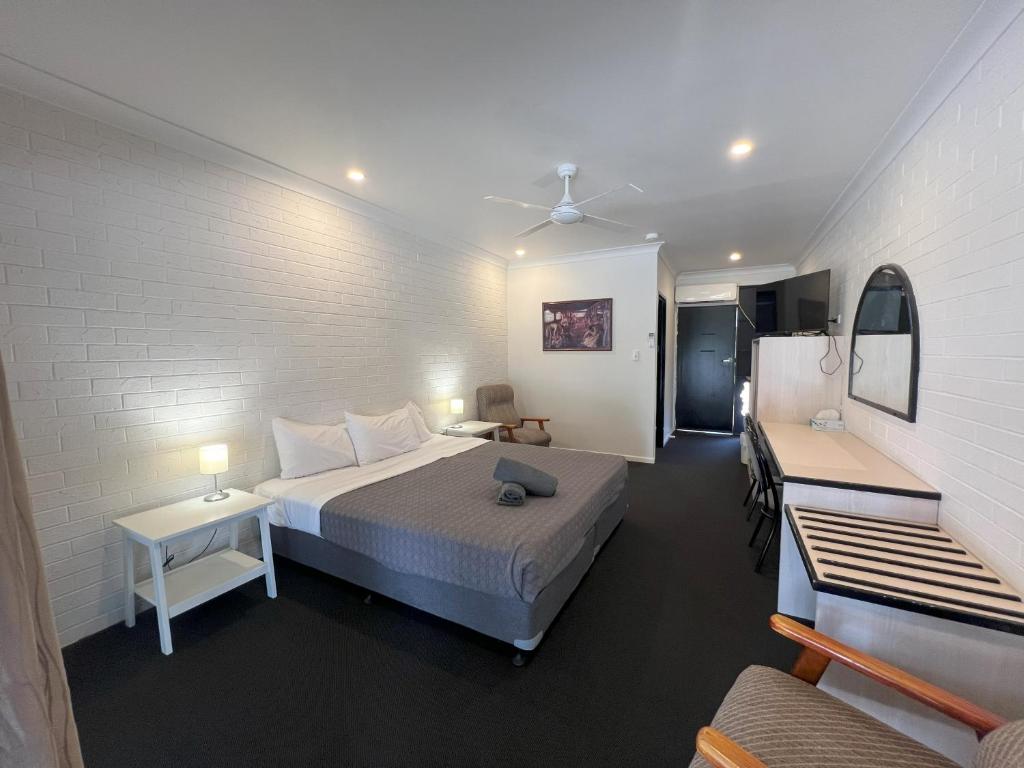a bedroom with a bed and a room with a couch at Abajaz Motor Inn - Oil Friendly Price in Longreach
