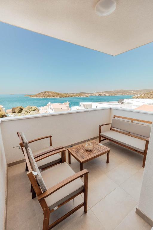 a room with chairs and a table and the ocean at Elia apartments in Ražanj