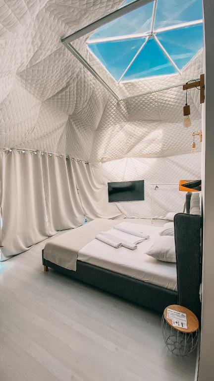a bedroom with a bed with a ceiling with a window at Seagloo Glamping - Adults Only in Costinesti