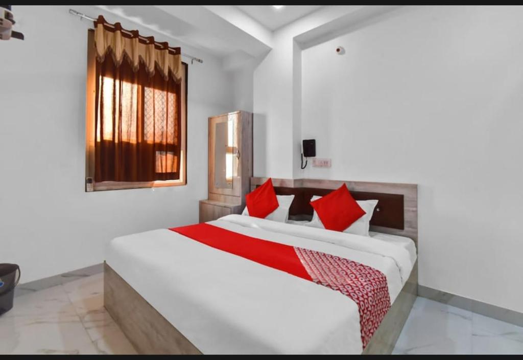 a bedroom with a large white bed with red pillows at Hotel Grand L M in Ajmer