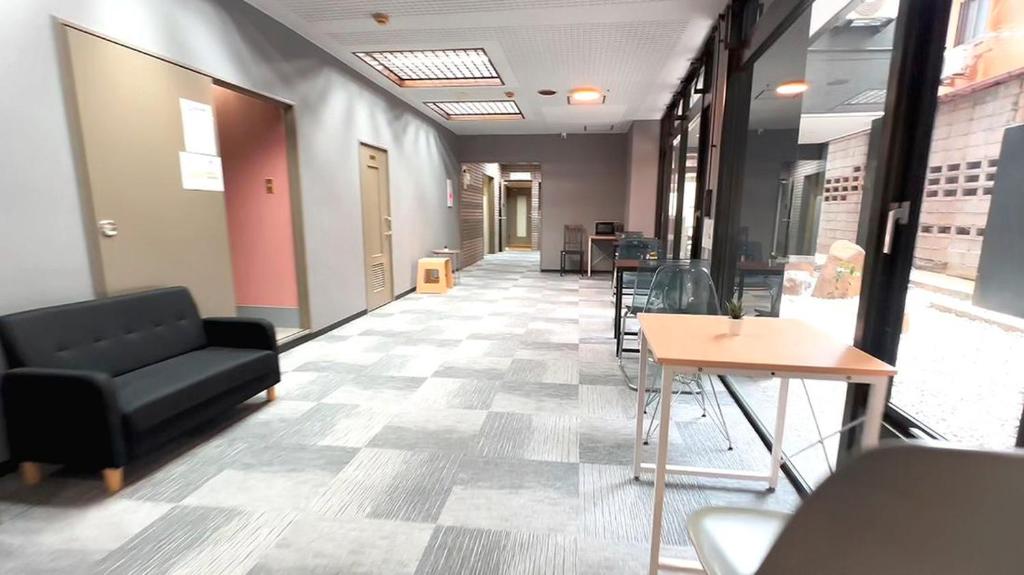 an office hallway with a couch and tables and chairs at 心斎橋難波関空直通Ambers 7708 in Osaka
