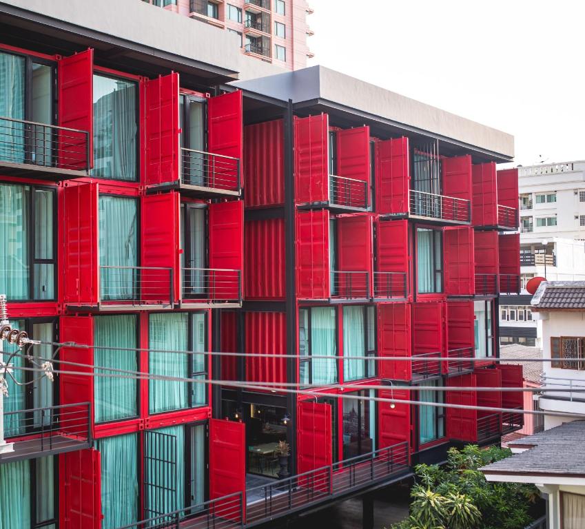 a red building with balconies on the side of it at Sleep Box Sukhumvit 22 in Bangkok