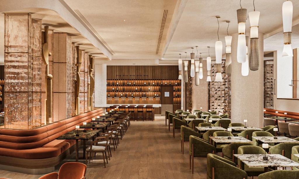 AC Hotel by Marriott Vilnius — A dining room with tables and chairs and chandeliers
