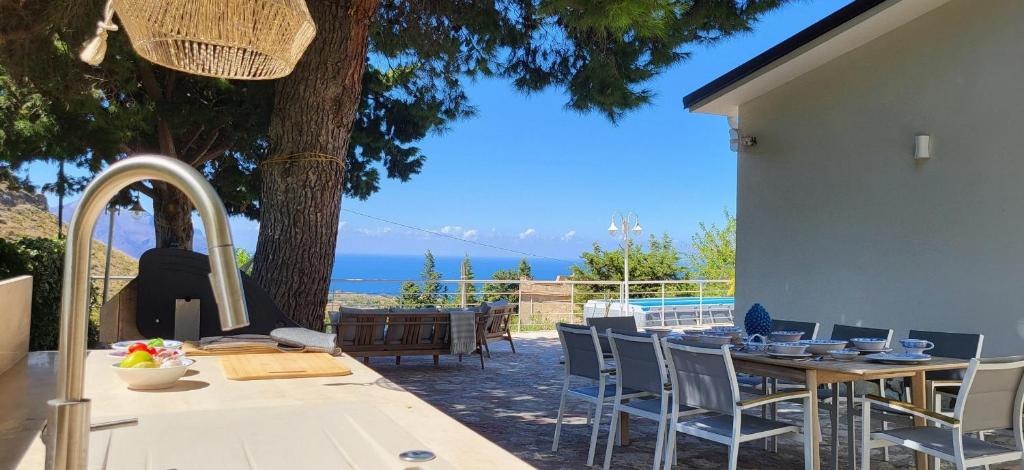 une table et des chaises avec vue sur l'océan dans l'établissement Villa Ballerina Bianca, à Scopello