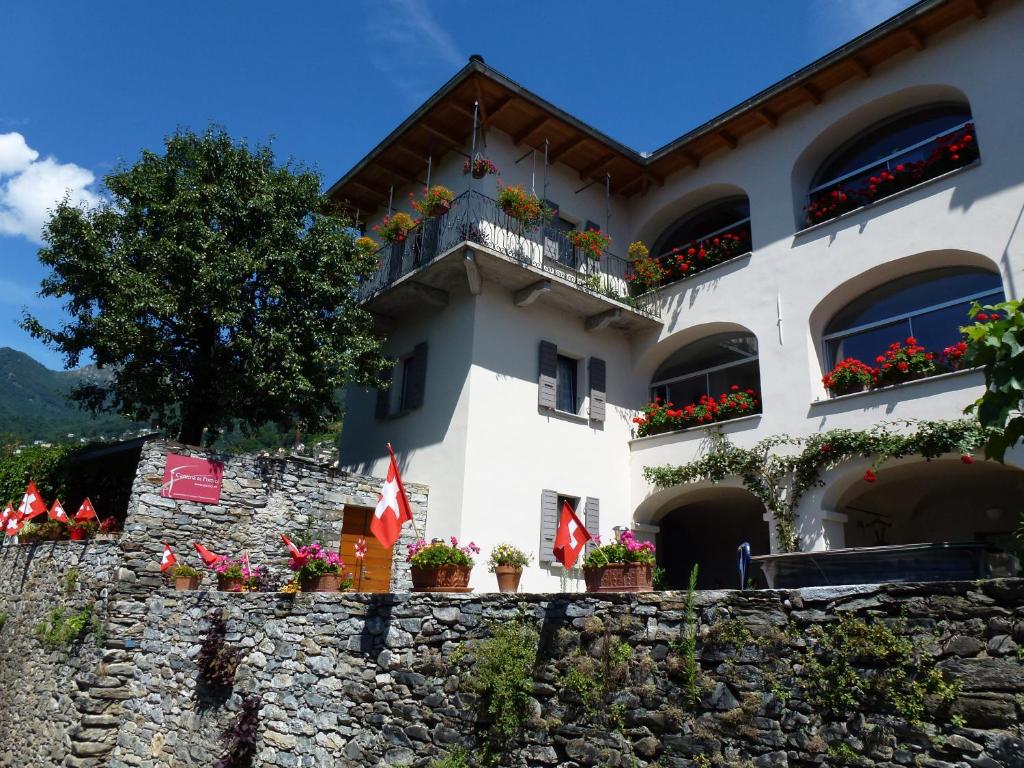 a building with potted plants on a stone wall at Casa Ai Portici in Gordola