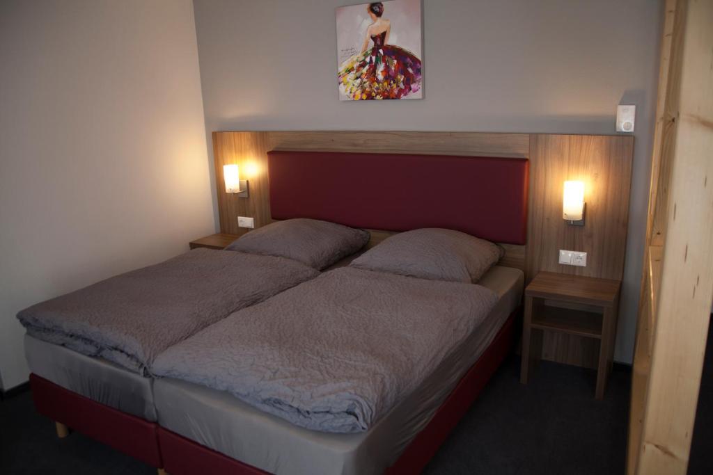 - une chambre avec un grand lit et 2 oreillers dans l'établissement La Flamme Wertheim garni, à Wertheim
