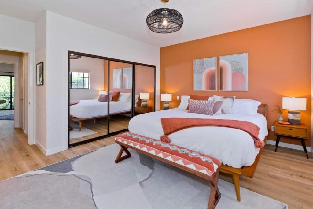 a bedroom with a large bed with an orange wall at Avocado Toast - Steps To Tennis, Pickleball, Golf in La Quinta