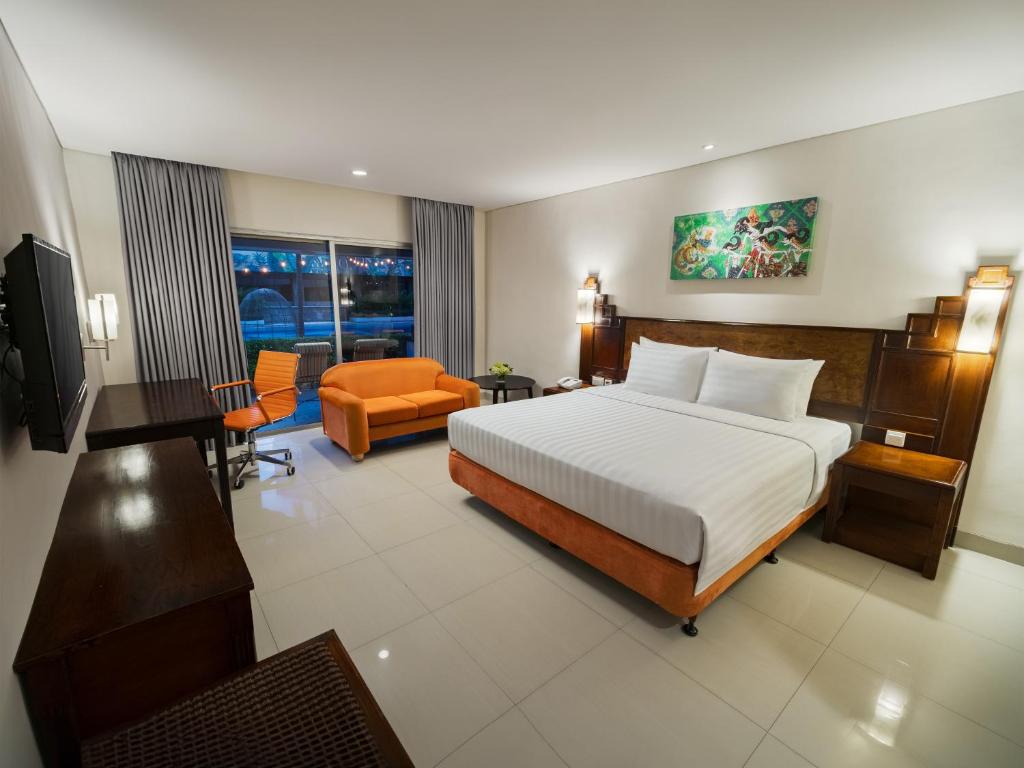 a hotel room with a bed and a living room at Grand Sahid Jaya in Jakarta