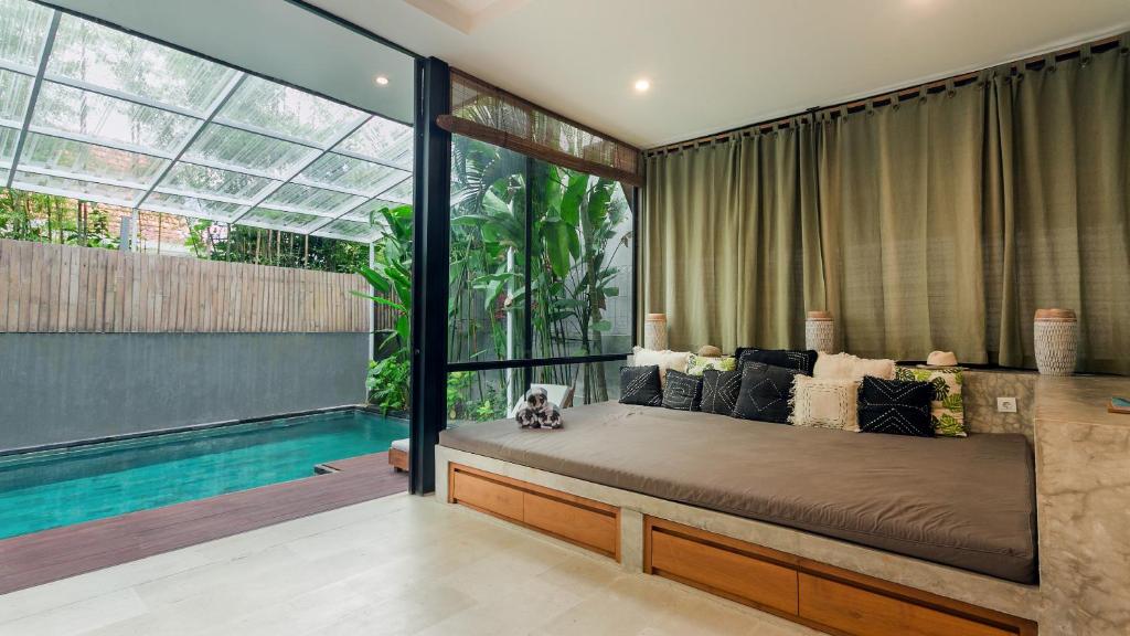 a bedroom with a large bed and a swimming pool at Kalino Villa by Betterplace in Canggu