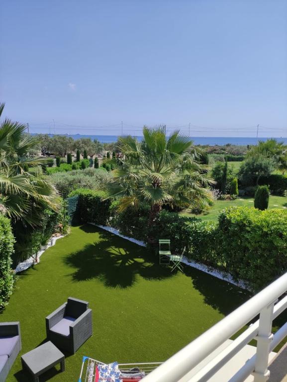 a view from a balcony of a lawn with palm trees at wonderful sea view in Antibes