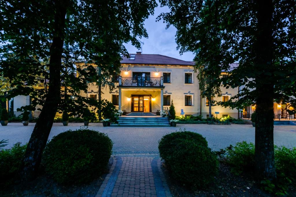 a large white house with a staircase in front of it at Park Rekreacyjno-Biznesowy Las Woda in Wilga