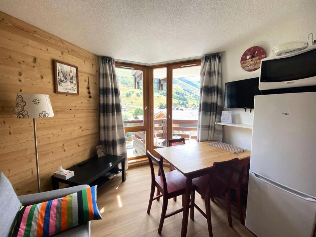 une cuisine et une salle à manger avec une table et un réfrigérateur dans l'établissement Résidence Grande Chaume - Super T2 face aux pistes et écoles de ski MAE-5241, à Vénosc