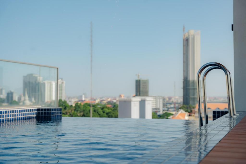 a swimming pool on top of a building with a city at The Scenic Hotel in Phnom Penh