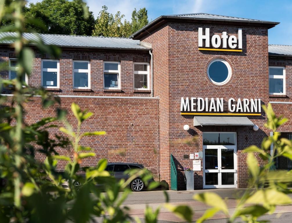 ein rotes Backsteinhotel mit einem Schild darauf in der Unterkunft Median Hotel Garni in Wernigerode