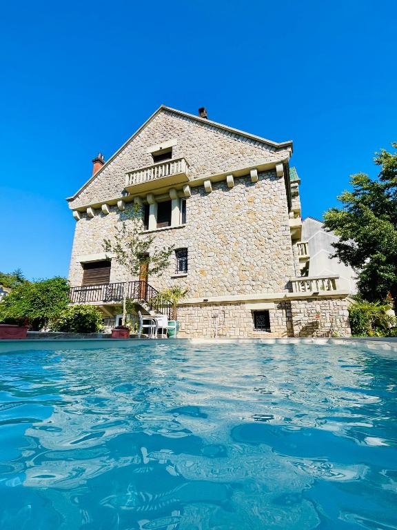 a building from the water in front at La Maison au toit vert in Espalion