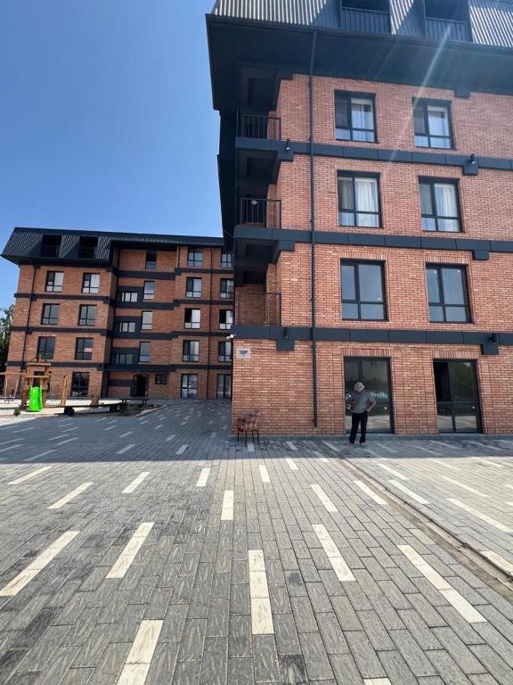 a person standing in front of a brick building at vzmorie apart in Bosteri