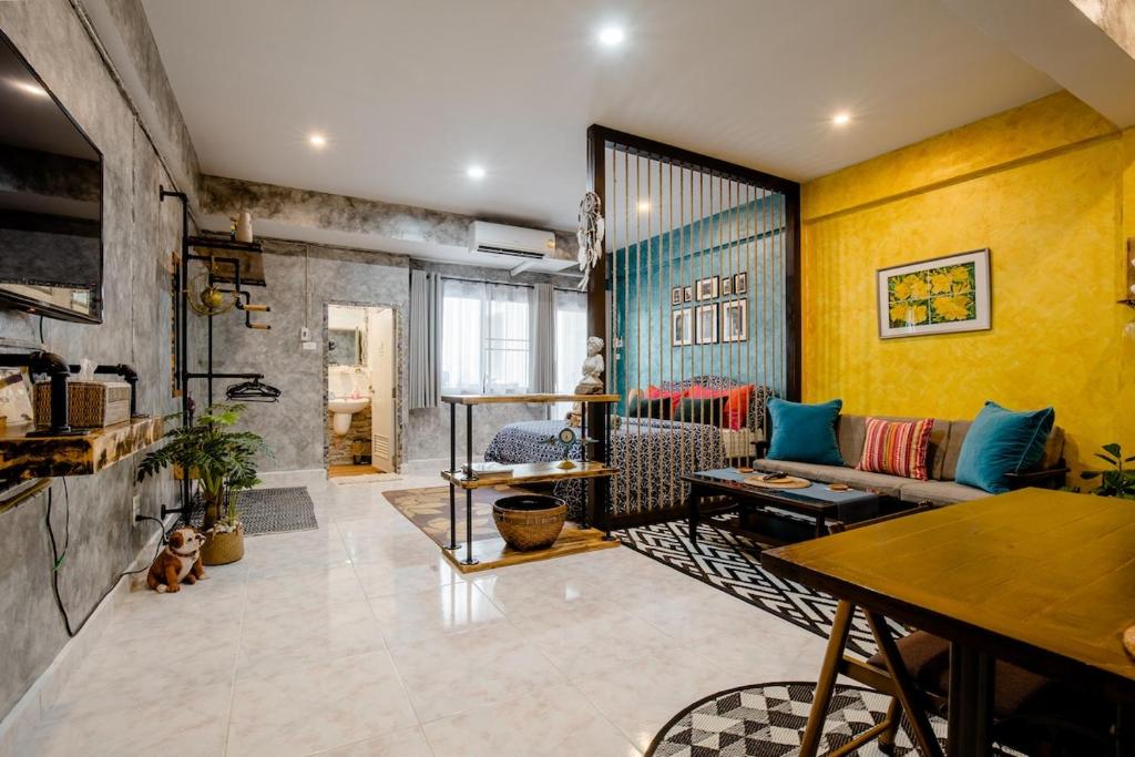 a living room with a couch and a table at Double Studio with Balcony & Private Bath by Smile Loft in Ban Na Song