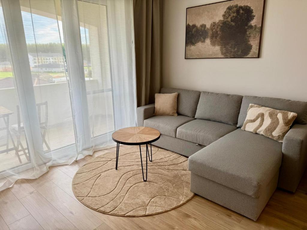 a living room with a couch and a table at Anna Apartment in Dunajská Streda