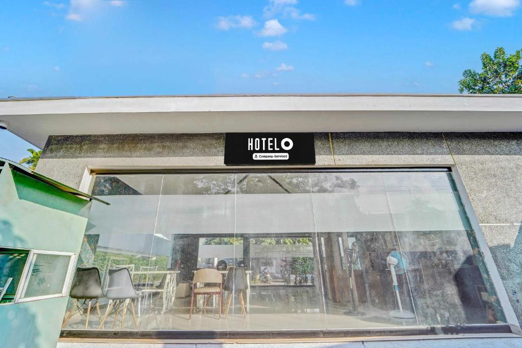 a window of a restaurant with a table and chairs at Hotel O Kalady Near Airport in Kāladi