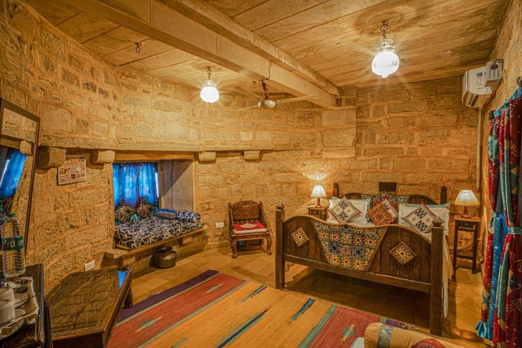 uma sala de estar cheia de mobiliário e uma parede de pedra em Hotel Rajmandir em Jaisalmer