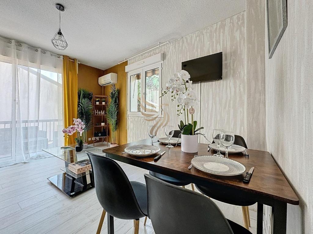 une salle à manger avec une table et des chaises en bois dans l'établissement 4p apt – terrace, A/C, WiFi – 100m beach, à Fréjus