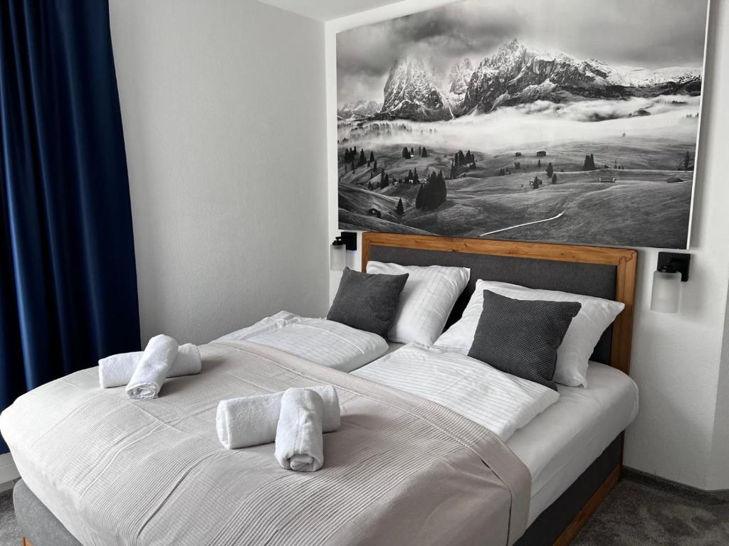 a bedroom with a bed with a painting on the wall at Alpenruhe Kranzegg in Rettenberg