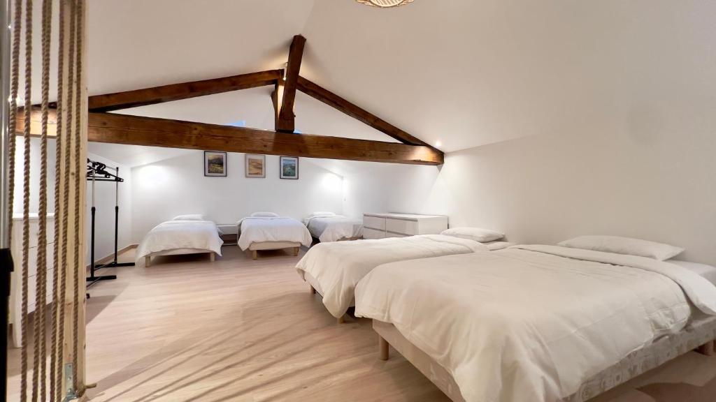 a bedroom with four beds in a room at La grange du château Favor in Bourg-de-Péage