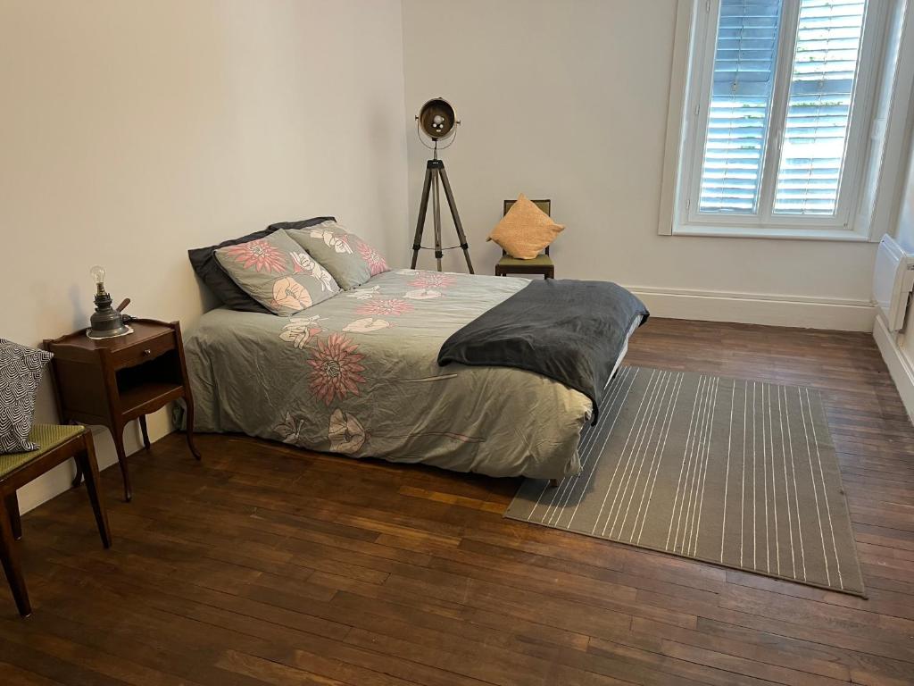 a bedroom with a bed and a wooden floor at La ferme 