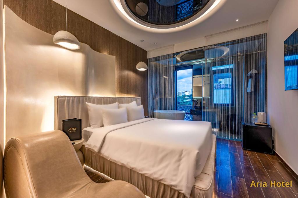 a hotel room with a bed and a chair at Oria Hotel Gò Vấp in Ho Chi Minh City