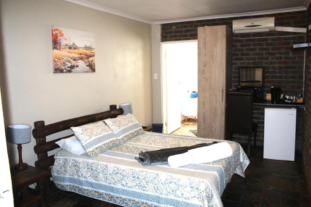 a bedroom with a bed and a brick wall at Delion Lodge in Koster