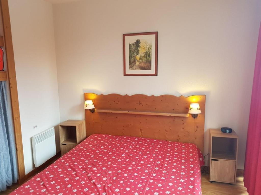 ein Schlafzimmer mit einem Bett mit einer roten Tagesdecke in der Unterkunft V du bachat joubarbes C N 02 - 3P5 in Chamrousse