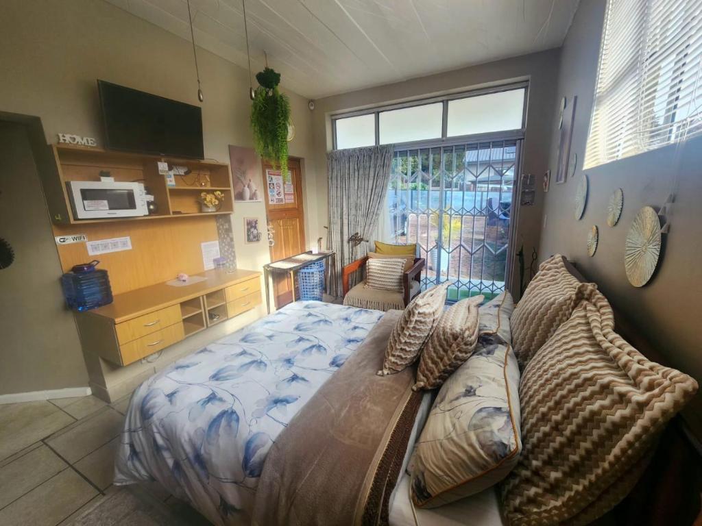 a bedroom with a large bed with pillows on it at Primrose Accommodation in George