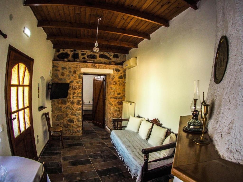 a living room with a couch and a stone wall at Castle's House in Véssa
