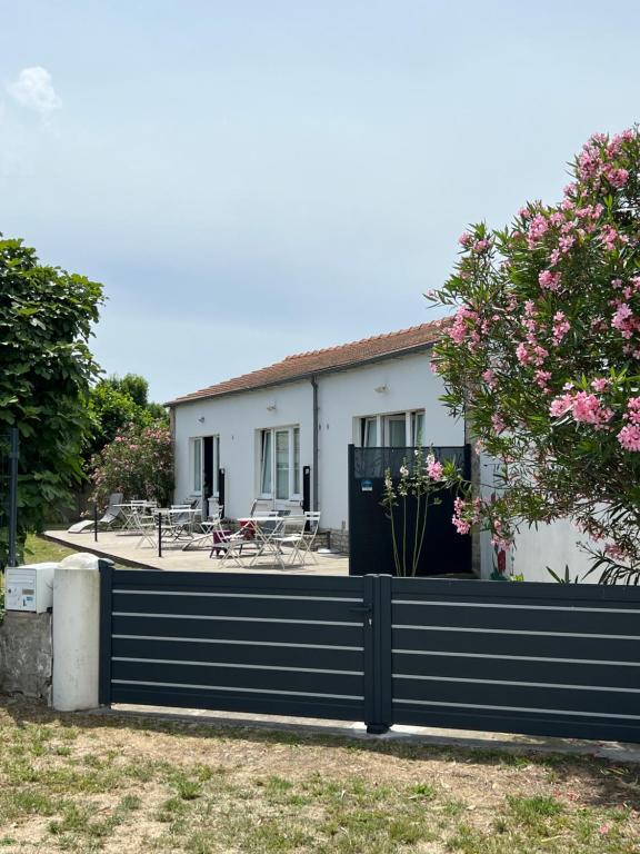 ein Haus mit einem Zaun davor in der Unterkunft La Tranquille - Maison pour 3 familles in La Michelière