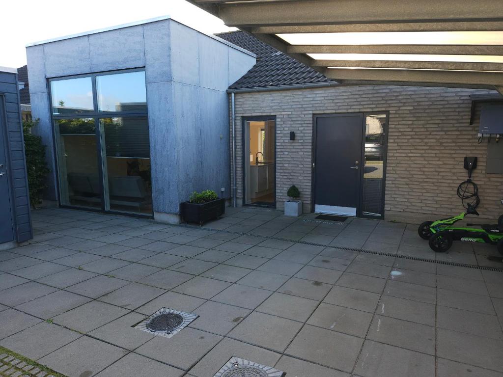 een terras met een scooter geparkeerd voor een gebouw bij Fam house in Malling