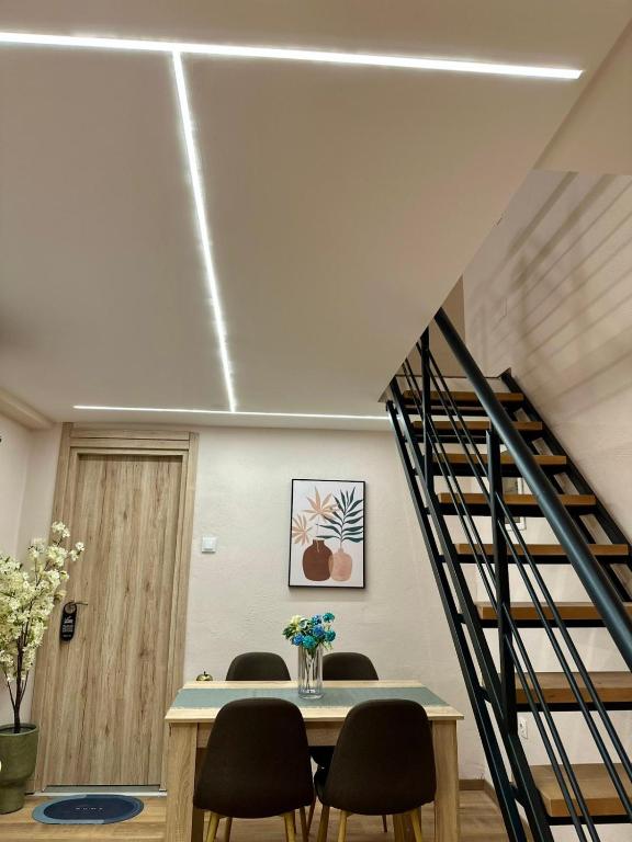 a room with a table and chairs and a staircase at Nomad Life in Volos