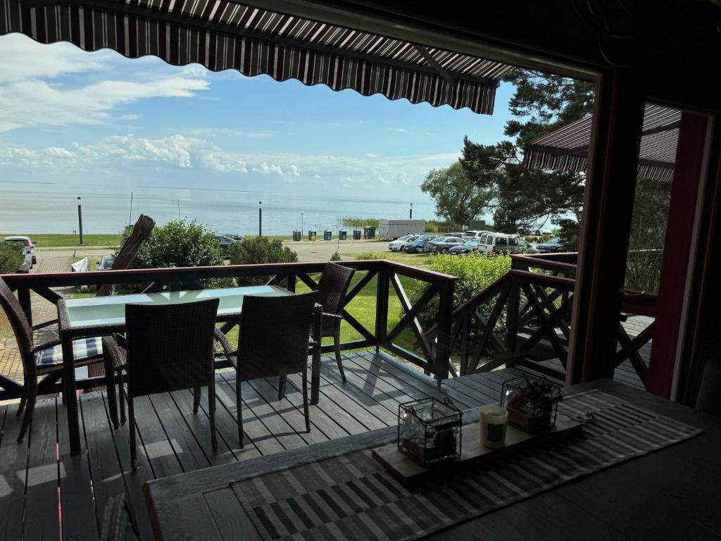 a porch with a table and chairs and a view of the ocean at Vėtrungių Namai in Nida