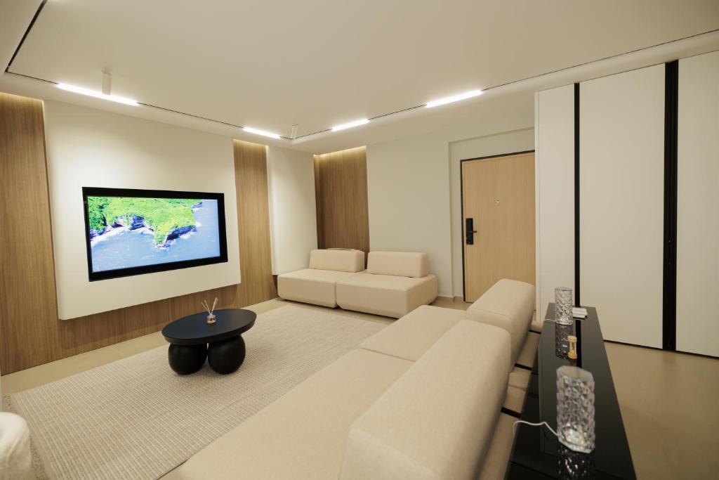 a living room with a white couch and a tv at Rayan Luxury Apartament Vlore in Vlorë